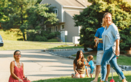 Families playing in grass on a peaceful neighborhood