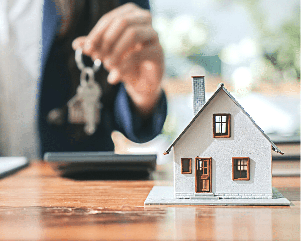 model house with a real estate agent holding a key