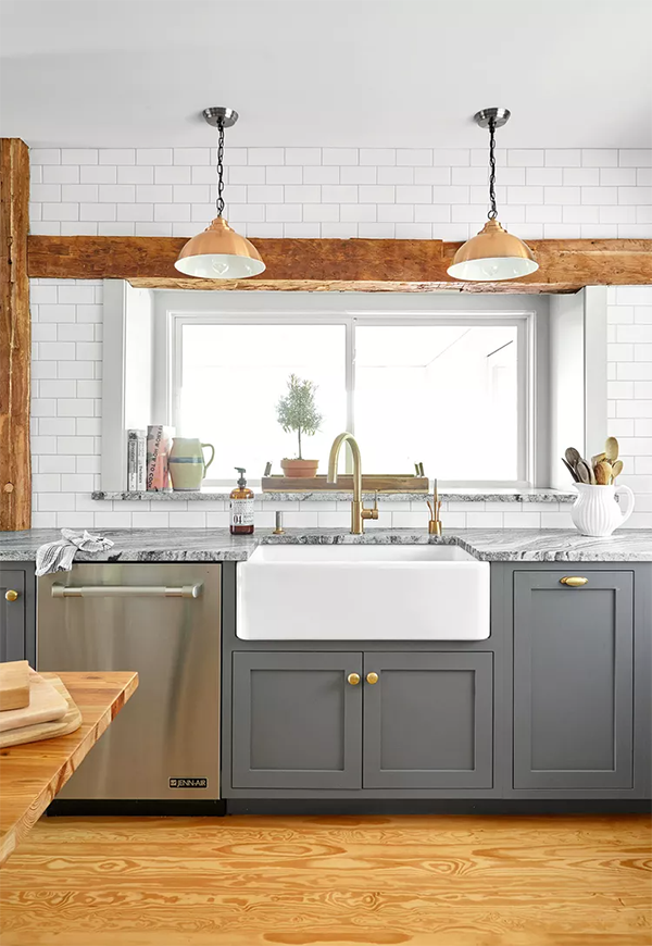 Blue-gray kitchen cabinets with gold accent and farmhouse sink