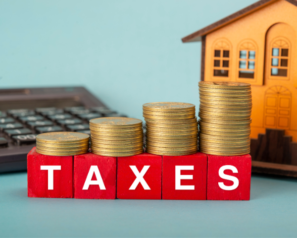 image of a house, money and calculator with the word Taxes in front