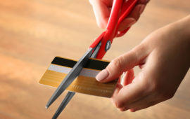 woman cutting her credit card with scissors