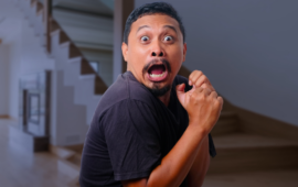 man looking scared inside a creepy house