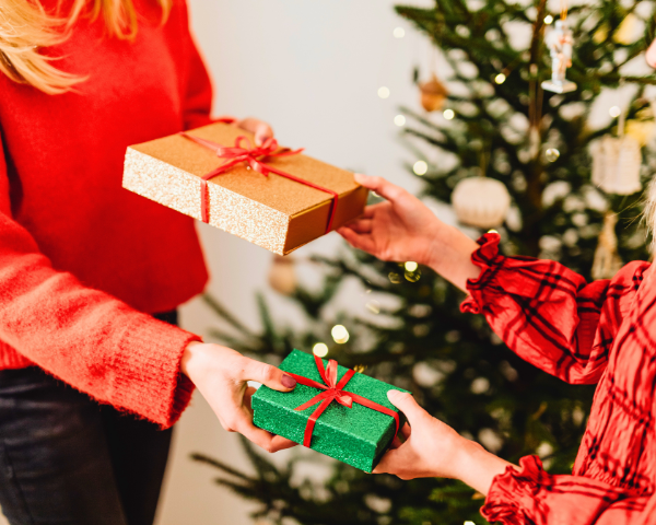 two people exchanging holiday gifts