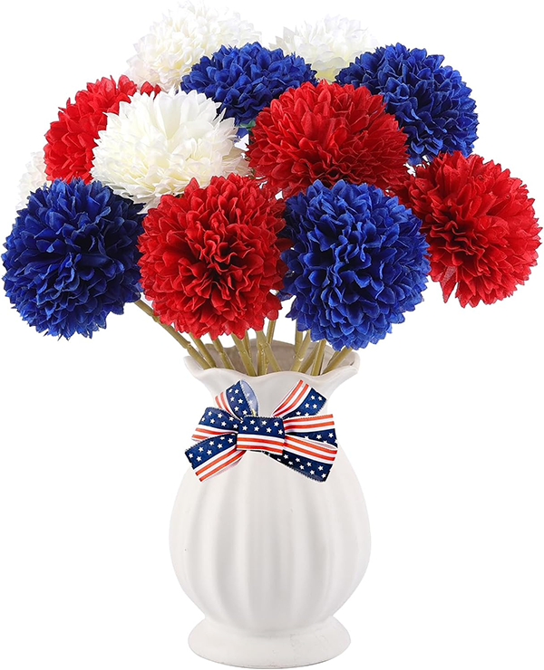 A bouquet of red, white, and blue pom-pom flowers in a white vase adorned with an American flag-themed bow, conveying a patriotic theme. A bouquet of red, white, and blue pom-pom flowers in a white vase adorned with an American flag-themed bow, conveying a patriotic theme.