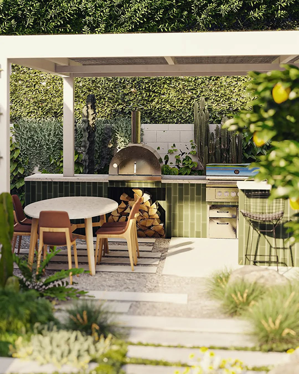 Outdoor kitchen with a modern design, featuring a wood-fired pizza oven, grill, round dining table, and green tiled counter, surrounded by lush greenery