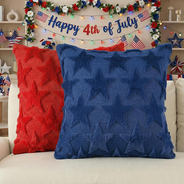 Red and blue star-patterned pillows on a white sofa with festive Happy 4th of July banner, lights, and American flags as decoration. Red and blue star-patterned pillows on a white sofa with festive Happy 4th of July banner, lights, and American flags as decoration.