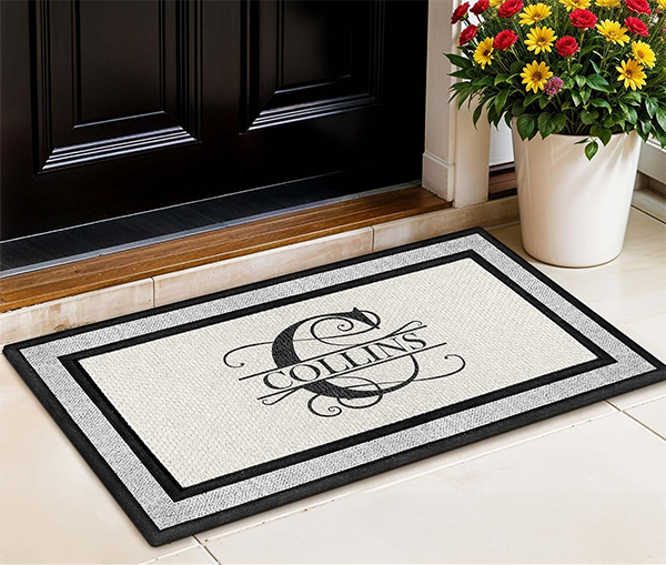 Two folded plaid linen towels embroidered resting on a dark patterned rug beside wooden frames